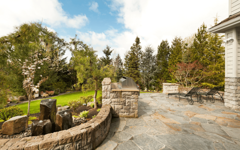 backyard greenery with brick and concrete pad